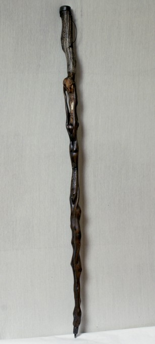 Les bras de la Femme se détachent du bâton, derrière, sont insérés des motifs en ivoire, cerclés d'étain.